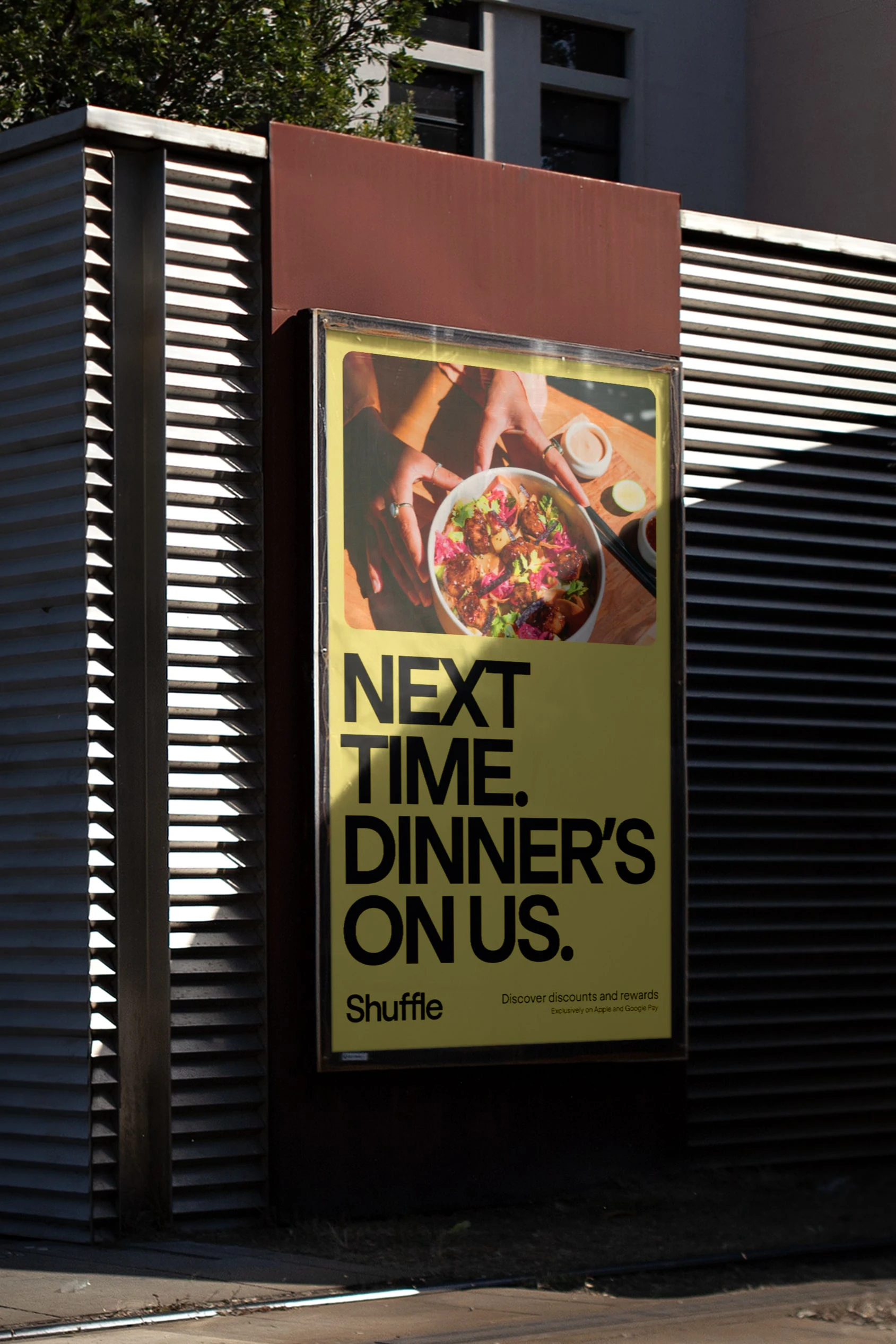 A yellow Shuffle poster behind a slatted shutter: “Next time. Dinner’s on us.”